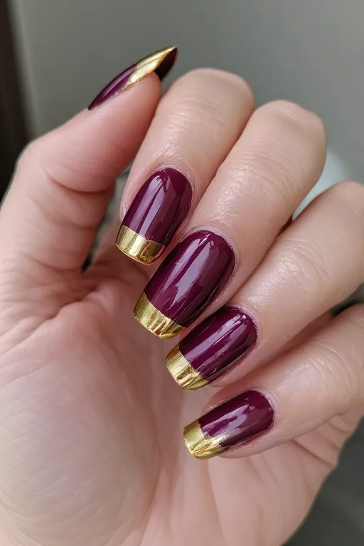 deep burgundy nails with gold chrome tips