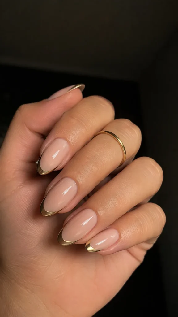 sheer nude almond nails with gold french tips